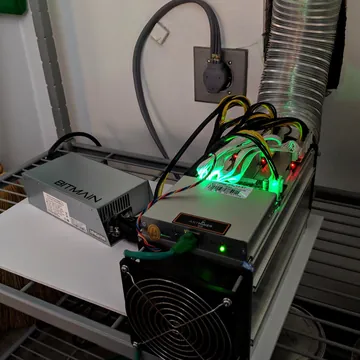 Antminer S9 running on a shelf next to its Bitmain power supply
